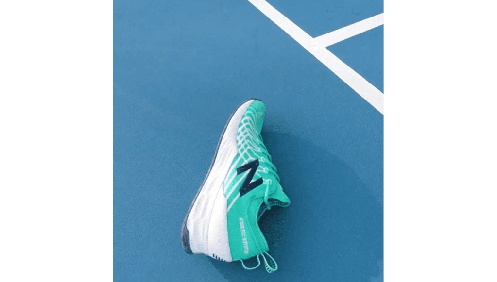 A tennis shoe is laying on the court.