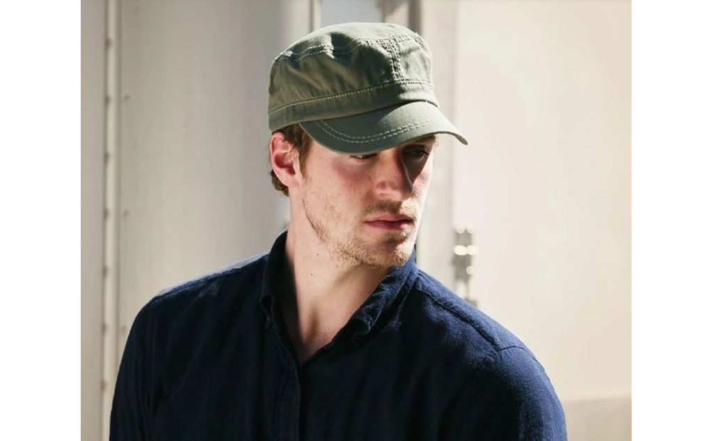 A man wearing a hat and looking at the camera.