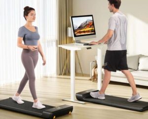 A woman and man are standing on a treadmill.