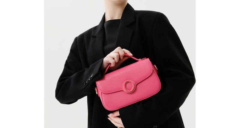 A woman holding onto a pink purse