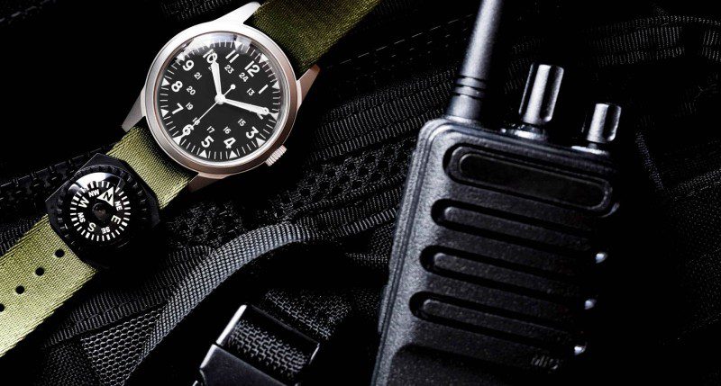 A watch and walkie talkie on the ground