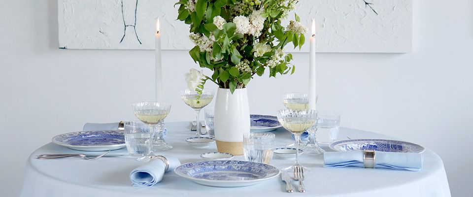 A table set with plates, glasses and candles.