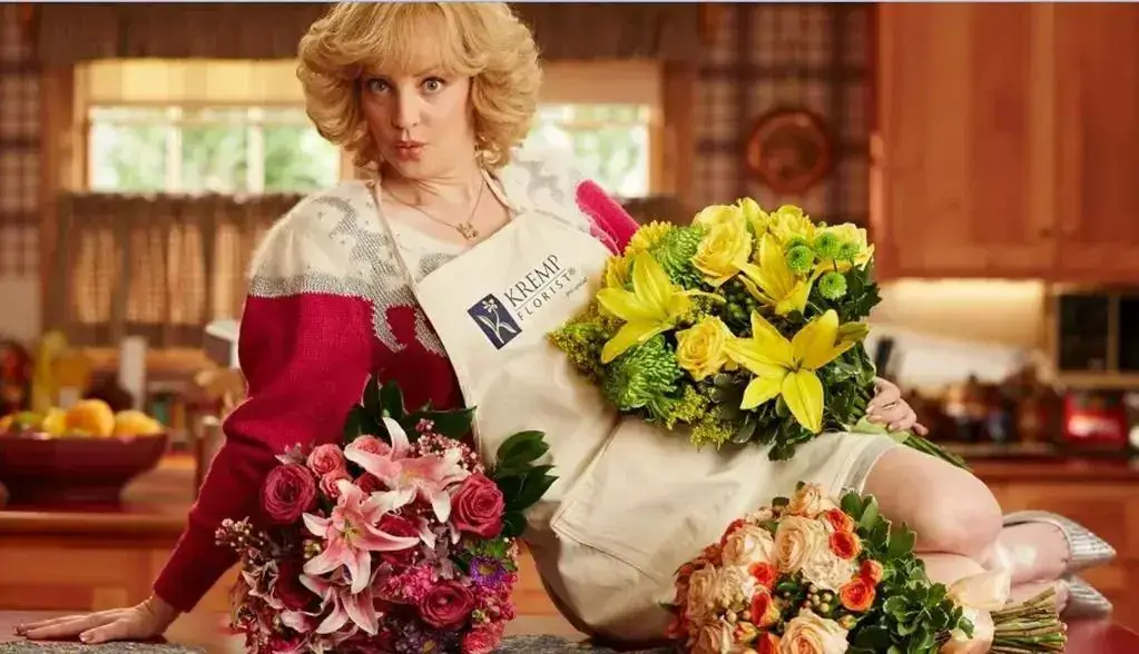 A woman holding flowers in front of her face.